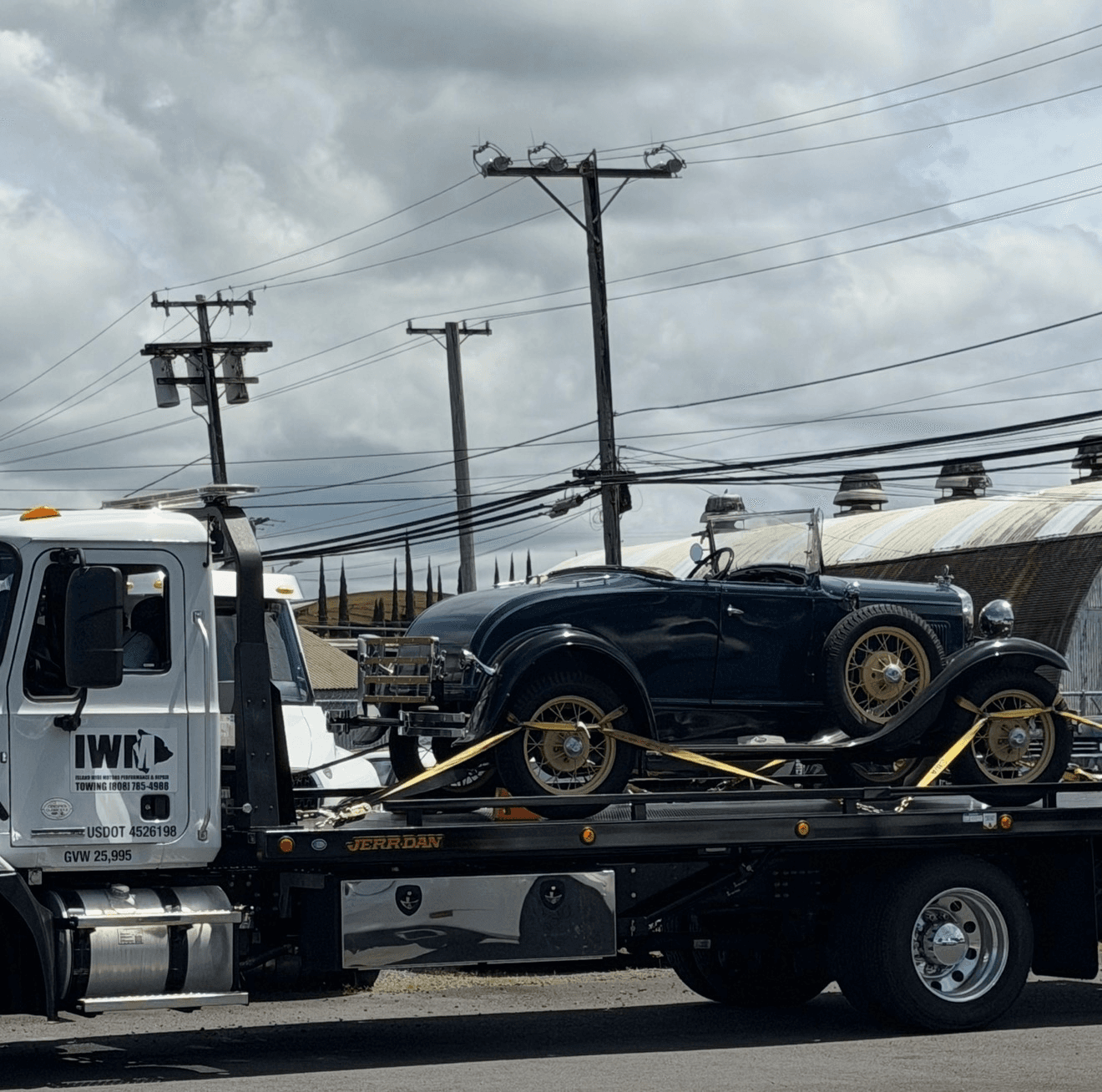Island Wide Motors flatbed towing a classic convertible in Hilo